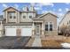 Charming townhome featuring a two-car garage, inviting entryway, and stone accents at 4733 Flower St, Wheat Ridge, CO 80033