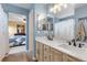 Elegant, blue toned bathroom featuring a double sink vanity with white countertops and warm, wooden cabinets at 6662 Fonder Dr, Parker, CO 80134