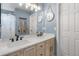 Bright bathroom featuring a double sink vanity with white countertops, warm cabinets, and modern light fixtures at 6662 Fonder Dr, Parker, CO 80134