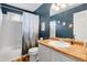 This updated bathroom features vinyl floors, a white tub and shower, and a wood topped vanity at 6662 Fonder Dr, Parker, CO 80134