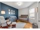 This Bedroom features hardwood floors, a dark blue accent wall, and a cozy rocking chair at 6662 Fonder Dr, Parker, CO 80134
