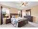 Spacious bedroom featuring carpeted floors, large windows, and matching dark wood furniture at 6662 Fonder Dr, Parker, CO 80134