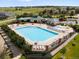 Community pool area with lounge chairs, umbrellas, and lush landscaping at 6662 Fonder Dr, Parker, CO 80134