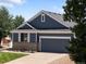 Charming exterior of a single-Gathering home featuring a gray siding, a well-manicured lawn, and an attached two-car garage at 6662 Fonder Dr, Parker, CO 80134