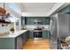 Modern kitchen featuring updated appliances, granite countertops, and stylish sage cabinets with light-colored walls and natural lighting at 6662 Fonder Dr, Parker, CO 80134