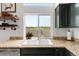 Granite countertops surround this double basin kitchen sink with a view to the open landscape at 6662 Fonder Dr, Parker, CO 80134