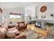 Open-concept living room featuring a fireplace, hardwood floors, high ceilings, and seamless access to the dining area with lots of natural light at 6662 Fonder Dr, Parker, CO 80134