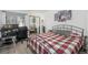 Bedroom with a metal frame bed, a plaid comforter, and a desk with computer and monitor at 532 Oakwood Dr # D202, Castle Rock, CO 80104