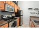 Kitchen with stainless steel appliances, tile countertops, and wood cabinets at 532 Oakwood Dr # D202, Castle Rock, CO 80104