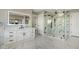 Bathroom features white cabinets, a large mirror, a glass shower, and marble-patterned tile at 24031 E Hinsdale Pl, Aurora, CO 80016