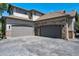 View of the three car garage with modern doors and a spacious concrete driveway at 24031 E Hinsdale Pl, Aurora, CO 80016