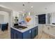 Kitchen features an island with gas cooktop, stainless appliances, and white cabinets at 24031 E Hinsdale Pl, Aurora, CO 80016