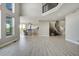 Bright and open living room with light wood floors, seamless flow to kitchen, and grand staircase at 24031 E Hinsdale Pl, Aurora, CO 80016