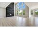 Bright living room with soaring ceilings, large windows, modern fireplace, and light wood floors at 24031 E Hinsdale Pl, Aurora, CO 80016
