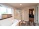 Bright bathroom with a soaking tub, glass-enclosed shower, and access to a walk-in closet at 14962 Williams St, Thornton, CO 80602