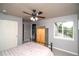 Cozy bedroom with soft gray walls, a ceiling fan, and backyard views through a sunny window at 14962 Williams St, Thornton, CO 80602