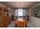 Formal dining room featuring a large wooden table, elegant lighting, and built-in cabinet at 14962 Williams St, Thornton, CO 80602