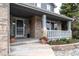 Inviting front porch with brick accents, decorative plants, and seating area at 14962 Williams St, Thornton, CO 80602