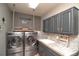 Well-appointed laundry room with washer, dryer, cabinetry, and a stylish countertop at 14962 Williams St, Thornton, CO 80602