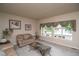 Cozy living room with neutral carpet, large windows, and comfortable seating at 14962 Williams St, Thornton, CO 80602