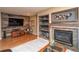 Living room with wood-paneled wall and a fireplace with decorative shelving and cabinets at 14962 Williams St, Thornton, CO 80602