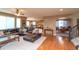 Open living room with hardwood floors, a large sofa, and an archway leading to the dining room at 14962 Williams St, Thornton, CO 80602