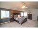 Relax in this spacious main bedroom that includes a wood accent wall and matching furniture at 14962 Williams St, Thornton, CO 80602