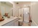 Cozy bathroom featuring a vanity sink with quartz countertops and a tiled shower at 4918 Preserve Pl, Firestone, CO 80504