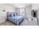 Comfortable bedroom with a bed, blue accents, and a bright window at 4918 Preserve Pl, Firestone, CO 80504