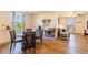 Bright dining area featuring hardwood floors, a wooden table, and views of the neighborhood through the large windows at 4918 Preserve Pl, Firestone, CO 80504