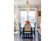 Bright dining room with modern light fixture, dark wood table and views to the backyard at 4918 Preserve Pl, Firestone, CO 80504