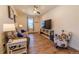 Cozy living room features hardwood floors, neutral-toned sofa, accent chair, and a TV at 4918 Preserve Pl, Firestone, CO 80504