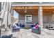 Relax in the shade on the outdoor patio with stone pillars and comfortable seating at 4918 Preserve Pl, Firestone, CO 80504