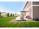 A view of the backyard with green grass, a patio with furniture and stone landscaping at 6922 Vermillion St, Frederick, CO 80530