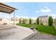 An open backyard featuring a well-maintained lawn, gravel area, and a covered patio at 6922 Vermillion St, Frederick, CO 80530