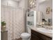 Neutral bathroom with shower-tub combo, decorative shower curtain, and ample storage at 6922 Vermillion St, Frederick, CO 80530