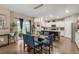 Open dining area with modern light fixture, glass table, and convenient access to the kitchen at 6922 Vermillion St, Frederick, CO 80530