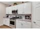 Well-lit kitchen featuring white cabinetry, stainless steel appliances and gray countertops at 6922 Vermillion St, Frederick, CO 80530