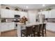 Modern kitchen features a large central island with seating, white cabinets, and stainless appliances at 6922 Vermillion St, Frederick, CO 80530