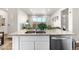 Kitchen island features a sink, dishwasher, breakfast bar, and elegant granite countertops at 9287 Twenty Mile Rd # 204, Parker, CO 80134