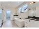 Bathroom featuring dual vanities, a soaking tub, and a separate glass-enclosed shower at 5575 Moosehead Cir, Longmont, CO 80503