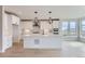 Modern kitchen with white cabinets, a center island, stainless steel appliances, and light hardwood floors at 5575 Moosehead Cir, Longmont, CO 80503