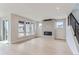 Bright living room with a modern fireplace, light hardwood floors, and large windows offering lots of natural light at 5575 Moosehead Cir, Longmont, CO 80503