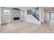 Open-concept living room featuring a modern fireplace, hardwood floors, and a staircase with metal railing at 5575 Moosehead Cir, Longmont, CO 80503