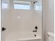 Bright shower with white tiled walls, black fixtures, and a window for natural light at 5575 Moosehead Cir, Longmont, CO 80503