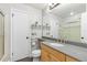 Bright bathroom featuring wood vanity, gray countertops, toilet, mirror and glass enclosed shower at 142 S Fillmore Ave, Louisville, CO 80027