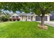 Charming single-story home featuring a lush green lawn, mature tree, and attached two car garage at 142 S Fillmore Ave, Louisville, CO 80027