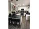 Full kitchen view featuring white cabinets, stainless appliances, black countertop, an island, and wood floors at 142 S Fillmore Ave, Louisville, CO 80027