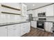 Modern kitchen featuring white cabinets, stainless steel appliances, and dark countertops at 142 S Fillmore Ave, Louisville, CO 80027