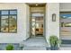Inviting entrance with modern glass door, stone accents, and interior chandelier view at 936 Sunflower St, Louisville, CO 80027